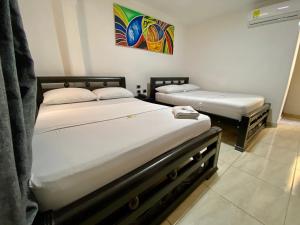 two twin beds in a room with a painting on the wall at HOTEL DIAMOND BGA in Bucaramanga
