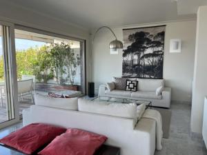 a living room with two white couches and a large window at Penthouse Cannes 100m2 avec 2 suites et terrasse 80m2 in Cannes