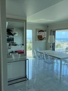 a white dining room with a table and chairs at Penthouse Cannes 100m2 avec 2 suites et terrasse 80m2 in Cannes