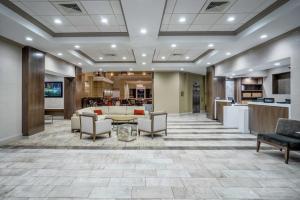 a lobby with a waiting area with chairs and a table at Embassy Suites Nashville - at Vanderbilt in Nashville