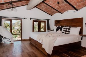 a bedroom with a large bed and two windows at DISTRITO 88 - Hotel Boutique Only Adults in Sayulita