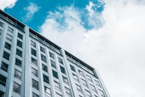 新奥尔良The Troubadour Hotel New Orleans的一座高大的白色建筑,背后是一片云天