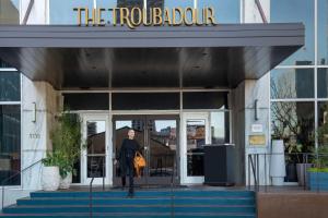 新奥尔良The Troubadour Hotel New Orleans的站在建筑物外的妇女