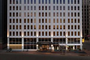 新奥尔良The Troubadour Hotel New Orleans的一座高大的白色建筑,前面有一间商店