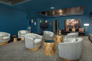新奥尔良The Troubadour Hotel New Orleans的一间带椅子的房间和一间带沙发的客厅