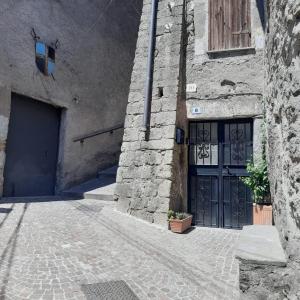 a stone building with a blue door and a doorway at La grotta in Fabrica di Roma