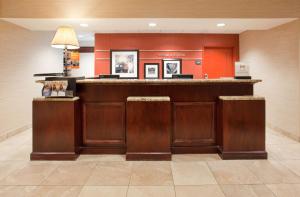 a bar in a hotel lobby with red walls at Hampton Inn & Suites Omaha Southwest-La Vista in La Vista