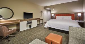 a hotel room with a bed and a television at Hampton Inn & Suites Roseburg in Roseburg