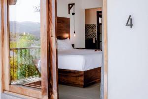 a bedroom with a bed and a view of a balcony at DISTRITO 88 - Hotel Boutique Only Adults in Sayulita