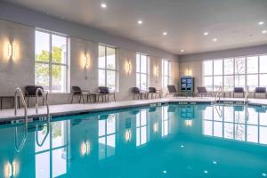 uma piscina num hotel com cadeiras e janelas em Homewood Suites by Hilton Philadelphia Plymouth Meeting em Plymouth Meeting