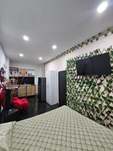 een slaapkamer met een televisie aan een muur met een plant bij Apartamentos del Sur in Itagüí
