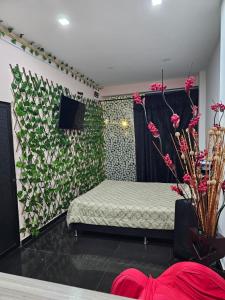 een slaapkamer met een bed en een muur met bloemen bij Apartamentos del Sur in Itagüí