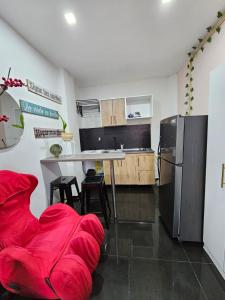 een keuken met een rode bank en een koelkast bij Apartamentos del Sur in Itagüí