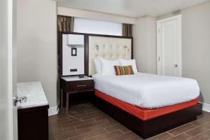 a hotel room with a bed and a mirror at Hotel Alex Johnson Rapid City, Curio Collection by Hilton in Rapid City