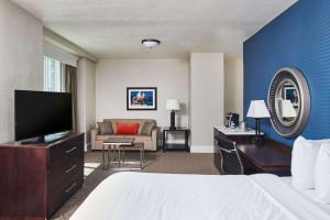 a hotel room with a bed and a television at Hotel Alex Johnson Rapid City, Curio Collection by Hilton in Rapid City