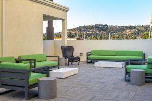 a rooftop patio with green couches and chairs at Homewood Suites By Hilton Belmont in Belmont