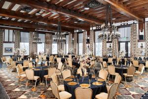 a banquet hall with tables and chairs and chandeliers at Hotel Alex Johnson Rapid City, Curio Collection by Hilton in Rapid City