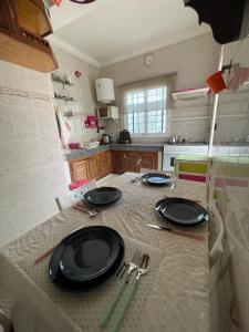 a kitchen with a table with black plates and utensils at Calm apartment with a comfy queen bed in Fez 4th floor in Fez