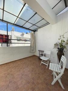 uma varanda com 2 cadeiras, uma mesa e uma janela em Calm apartment with a comfy queen bed in Fez 4th floor em Fez
