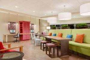 ein Wartezimmer mit einem Sofa, Tischen und Stühlen in der Unterkunft Home2 Suites By Hilton Youngstown in Youngstown