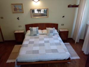 - une chambre avec un lit à damiers et 2 tables dans l'établissement Albergo Milano 1920, à Blevio