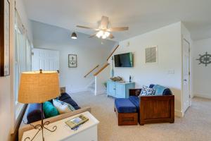 a living room with a blue couch and a ceiling fan at Near Ocean Buxton Townhome with Patio! in Buxton
