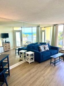 a living room with a blue couch and views of the ocean at Waters Edge - Ocean View at Symphony Beach Club in Ormond Beach