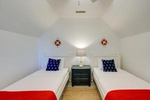two twin beds in a room with a night stand at Pet-Friendly Buxton Vacation Rental Near Ocean! in Buxton