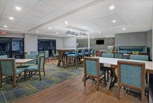 an empty waiting room with tables and chairs at Hampton Inn Westfield in Westfield