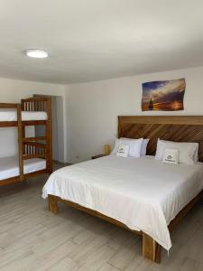 a bedroom with a bed and a bunk bed at Hotel El Quemaito - Luxury Oceanfront Retreat in Santa Cruz de Barahona