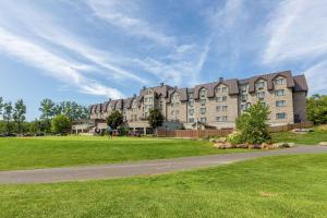 a large building in a park with a grass field at DoubleTree by Hilton Quebec Resort in Quebec City