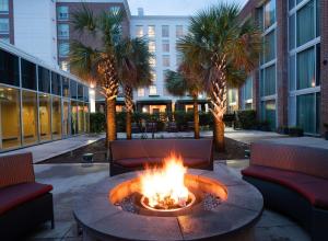 un focolare nel mezzo di un cortile con palme di Homewood Suites By Hilton North Charleston a Charleston