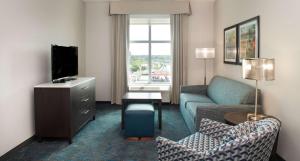 a living room with a couch and a tv at Homewood Suites By Hilton North Charleston in Charleston