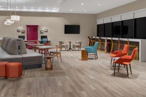 una sala de espera con mesas y sillas coloridas en Home2 Suites By Hilton Carlsbad New Mexico, en Carlsbad