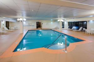 a swimming pool in a large room with tables and chairs at Hampton Inn & Suites Augusta West in Augusta