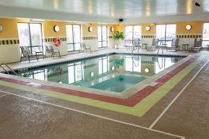 a swimming pool in a building with tables and chairs at Hampton Inn Yorkville in Yorkville