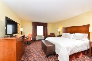 a hotel room with a bed and a flat screen tv at Hampton Inn Yorkville in Yorkville