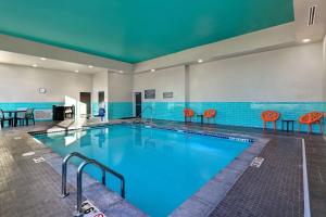 una gran piscina con sillas rojas en un edificio en Hilton Garden Inn Cedar Rapids en Cedar Rapids