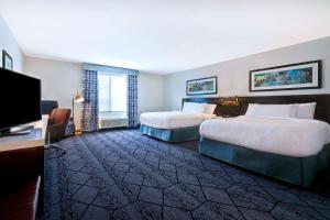 锡达拉皮兹Hilton Garden Inn Cedar Rapids的一间有两张床和一台平板电视的酒店房间