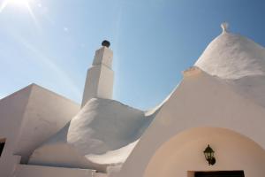 a lighthouse in front of a white building at Trulli Sarmenzanello in Noci