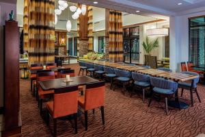 a restaurant with tables and chairs and a bar at Hilton Garden Inn Uniontown in Uniontown