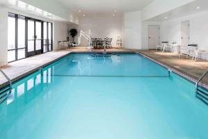 a large swimming pool with blue water in a building at Hampton Inn Kansas City/Shawnee Mission in Shawnee