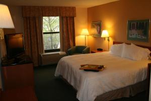 a hotel room with a bed with a tray on it at Hampton Inn Kansas City/Shawnee Mission in Shawnee