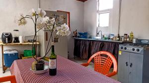 a kitchen with a table with a bottle of wine and flowers at Mico Loco Casa Hostal in Bogotá