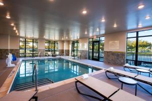 a large swimming pool with tables and chairs in a building at Hampton Inn & Suites Keller Town Center in Keller