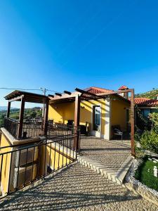 a yellow house with a gate and a balcony at Quinta do Sonho in Resende