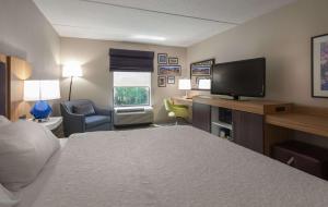 a hotel room with a bed and a flat screen tv at Hampton Inn Doylestown in Warrington