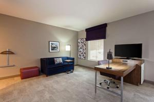 a living room with a blue couch and a tv at Hampton Inn & Suites Leavenworth in Leavenworth