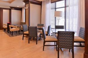 a dining room with tables and chairs and a window at Hampton Inn Potsdam in Potsdam