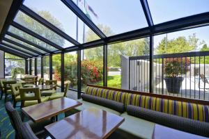 um restaurante com mesas, cadeiras e janelas em Hampton Inn Seattle/Southcenter em Tukwila